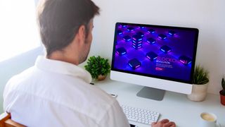 Mann sitter foran en PC med en nettside med teksten "blockchain revolution" på skjermen.