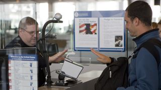 En grenseoffiser ved George Bush interkontinentale flyplass i Houston instruerer en innkommende passasjer til å bruke flyplassens biometriske scanner. I 2008 ble et nytt system som scannet ti i stedet for to fingre implementert.