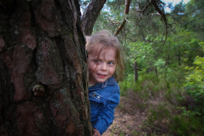 Miriam Ødegård dukker opp bak et tre.