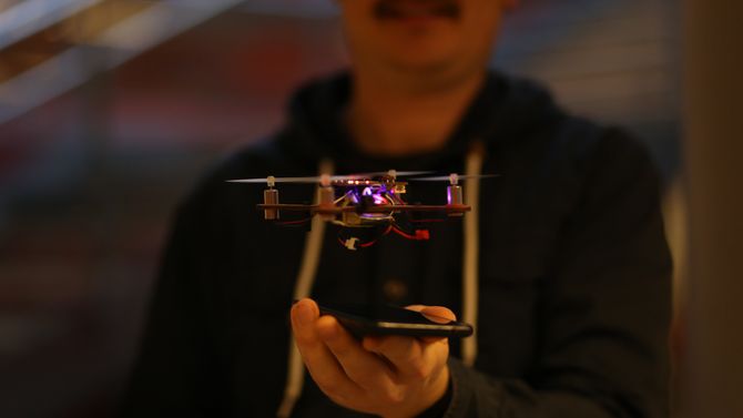 Henning Pedersen i bakgrunnen med en flyvende drone i forgrunnen.