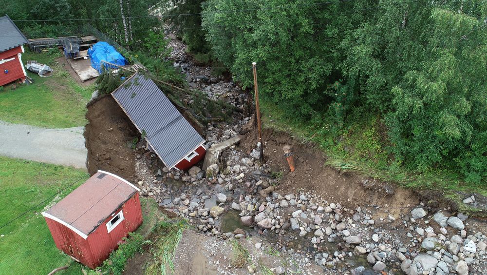 Store nedbørsmengder førte til flom og oversvømmelse i Brumunddal i sommer. Veien ble vasket bort og et uthus ble tatt av vannmassene.