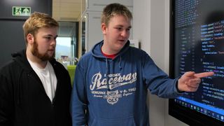 Ole Mathias Gullvåg (t.v) og Daniel Christensen ser på en skjerm som blant annet viser kildekode.