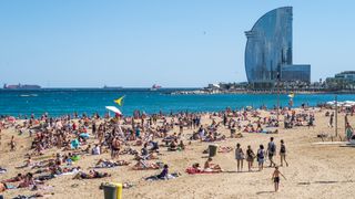 Turister på stranden i Barcelona i Spania