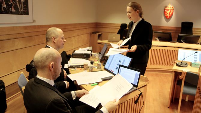 Advokatfullmektig Hanne Inger Bjurstrøm Jahren fra Regjeringsadvokaten deler ut sakspapirer til motparten. Til venstre partshjelper, advokat Einar Brunes fra PBL.