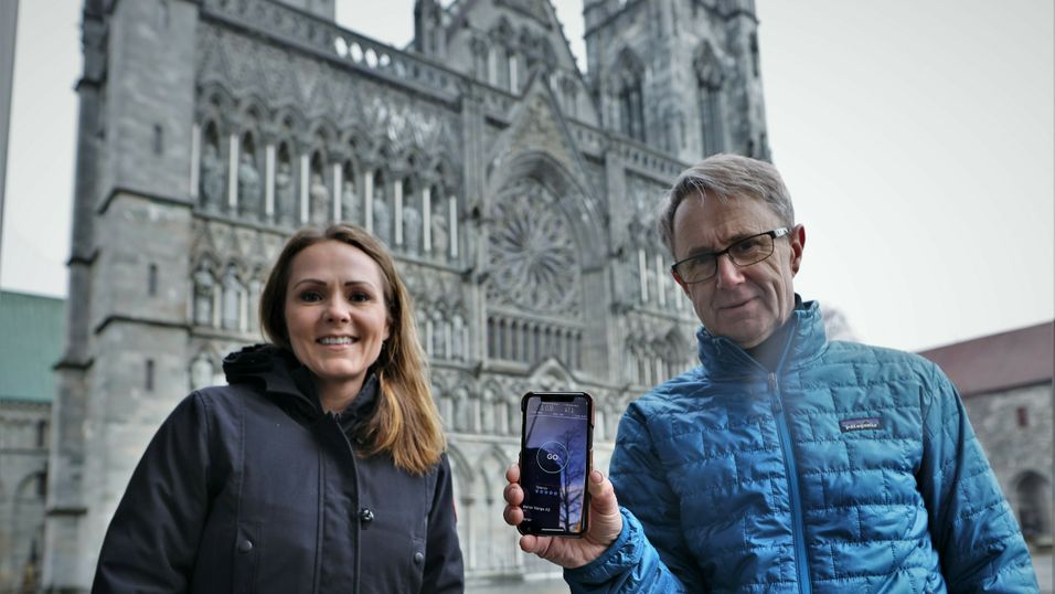 Distrikts- og digitaliseringsminister Linda Hofstad Helleland og dekningsdirektør Bjørn Amundsen i Telenor tester 5G foran Nidarosdomen i Trondheim sentrum.