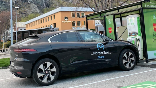 Ej Jaguar I-Pace i Norgestaxi-drakt ved hurtiglader i Årdal.