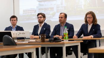 De fire lagdeltakerne sitter ved en pult siden av hverandre foran et projektor-lerret.