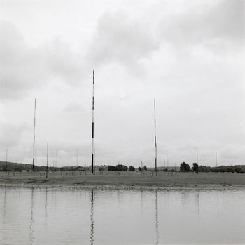 De tre første 122-metersmastene ved Jeløy Radio sett fra Gullholmsundet. Bildet er fra før 1956, da nordfløyen ble bygget og den fjerde store masten ble reist.