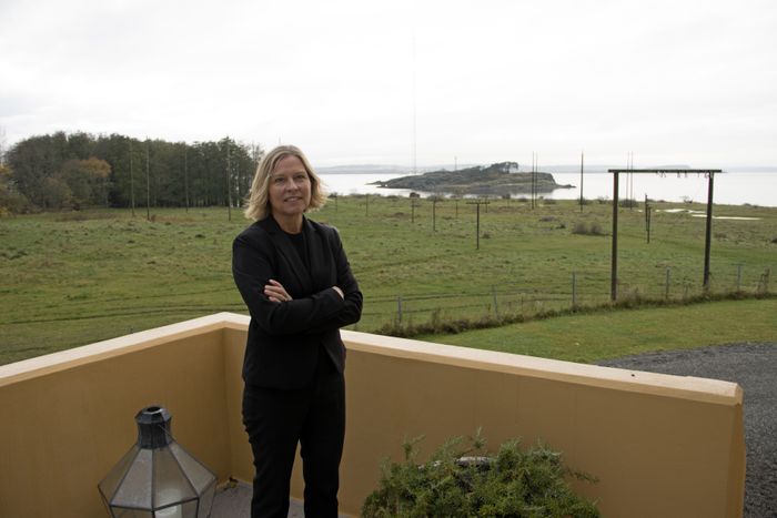 Kirsti Albert, hotelldirektør ved Jeløy Radio, foran en skog av antennemaster.