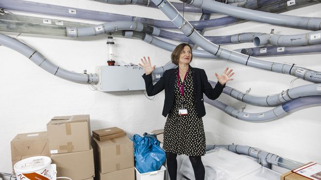 Stortingsdirektør Marianne Andreassen foran deler av rørpostsystemet på Stortinget.