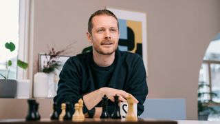 Simen Øian Gjermundsen med et sjakkbrett på bordet.