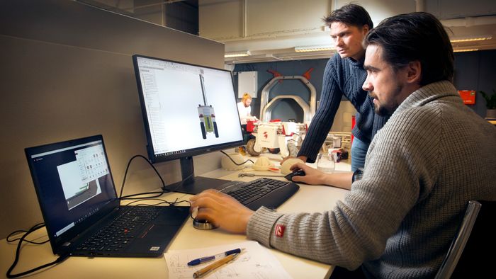 Selv om etterspørselen etter Thorvald-roboten er stor, betyr ikke det at selskapet tar en pust i bakken. Mekanisk designer Sergey Maximov jobber videre med nye moduler og forbedringsmuligheter. CEO Pål Johan From følger med. Til høyre for skjermen står noen 3D-printede utkast til design av jordbærplukkeren.