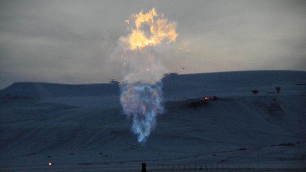 Brenning av skifergass fra brønn nær Longyearbyen, Svalbard. Gruve 7 i bakgrunnen.