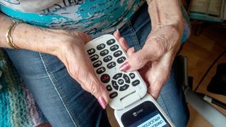 Eldre uten digitale ferdigheter bør få enkel tilgang til et analogt koronasertifikat, mener eldreombudet. Bildet viser en eldre dame med telefon.