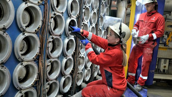 Det kreves stor nøyaktighet og grundighet under tilrigging før støping av aluminiumbolter. Her er Sara Lemicka Brix og Jonatan Espeland i gang med å støvsuge åpningene i støpebordet før nytt metall kan fylles i.