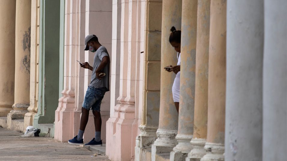 Tilgangen til mobilnettet og internett er delvis gjenopprettet på Cuba etter tre dager med avbrudd i kjølvannet av protester. Bildet viser et par innbyggere i Havana som bruker mobiltelefon med forhåndsbetalt tilgang til wifi-forbindelse.