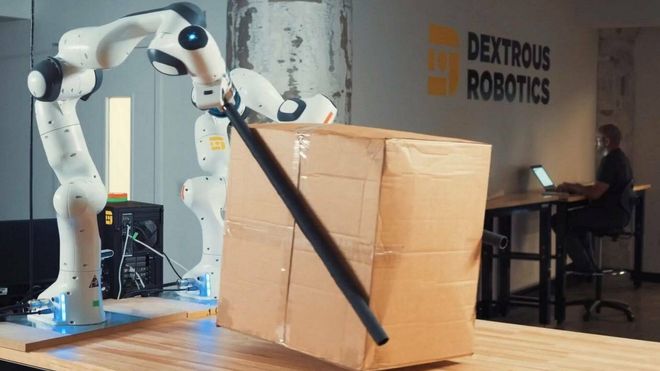 Robot holder en pakke ved hjelp av "spisepinner".