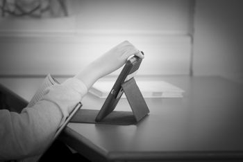 Student som leser og trykker på en iPad