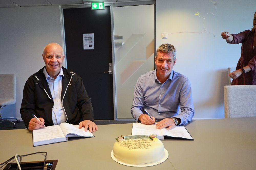Gv. Harald Even Fosse og Svenn Finden under signering. Konfetti er i luften.