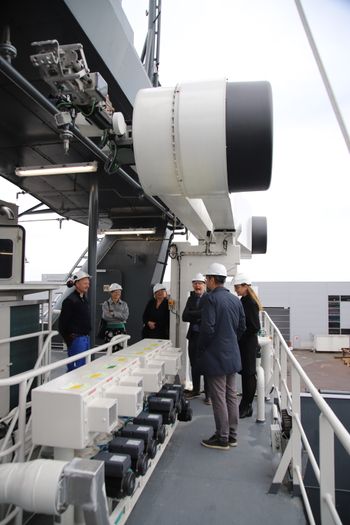 En delegasjon fra Kongsberg Maritime under den automatiske fortøyningsroboten fra MacGregor i Kristiansand. Yara Birkeland har en forut og en akter på styrbord side.