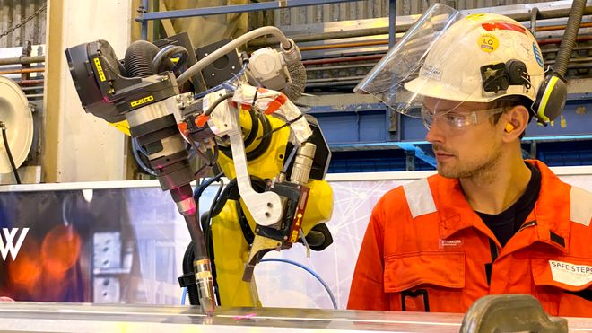 Robotoperatør Kristian Rundhovde Økland overvåker tester med automatisk robotsveising av aluminiumsprofiler. 