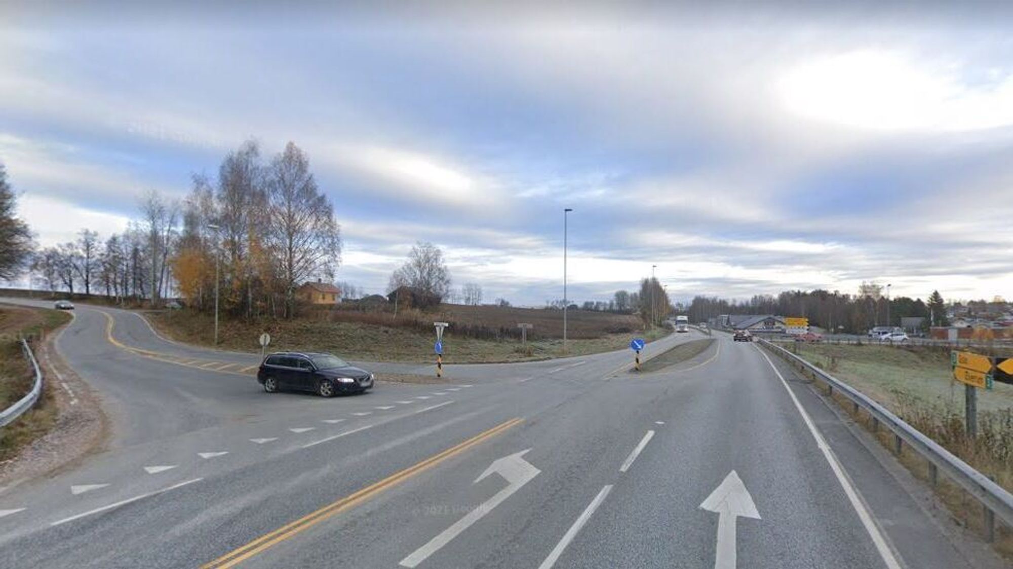 Selve Veenskrysset. Her blir det store endringer. Nærmest kommer Kirkevegen ned på fylkesveien. 50 meter lenger bort kommer Stasjonsveien fra Løten sentrum inn fra høyre. 
