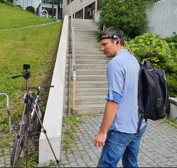 SINTEF-forsker og akustiker Tron Vedul Tronstad sjekker utstyret som skal brukes før joggeøkta  i trappa han står ved.