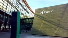 Telenors hovedkvarter på Fornebu med Telenors logo på grå murvegg