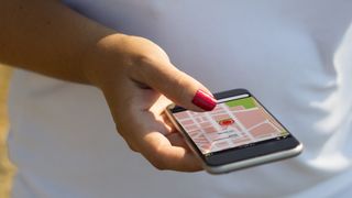 En kvinne holder en smarttelefon med gps-funksjon på skjermen