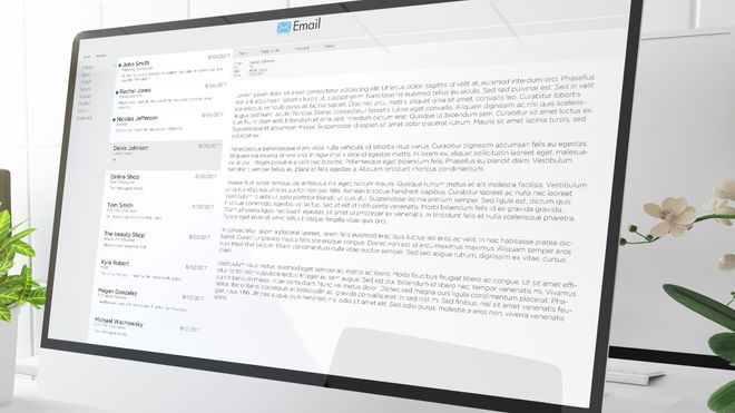 En kontorpult med en stor skjerm som viser en e-post-konto