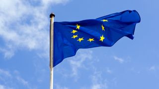 EU-flagget som vaier i vinden foran en blå himmel