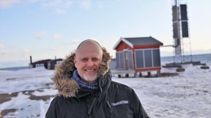 Christian Skottun, her foran en av basestasjonene på Svalbard. Allerede i 2019 tok Telenor Svalbard solenergi i bruk ved flere av sine basestasjoner for å redusere bruken av fossil energi. 