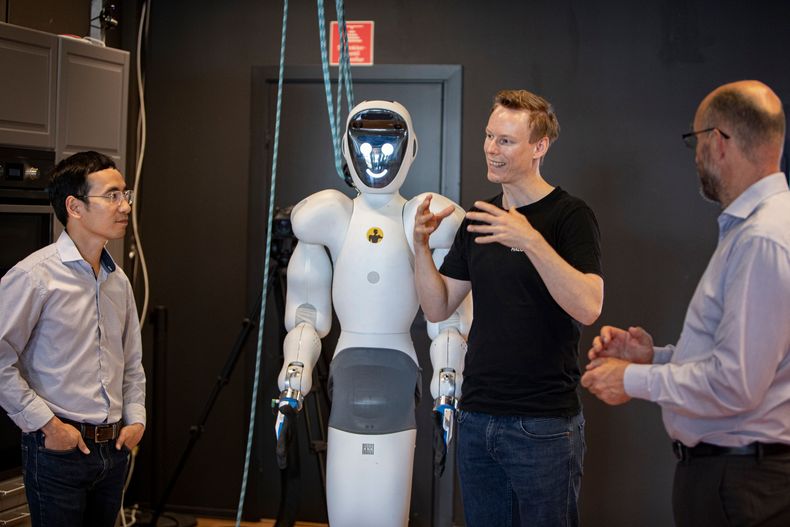 Teknologisjef Phuong Nguyen (t.v.), administrerende direktør Bernt Øivind Børnich og operativ leder Stein Erik Maurice står rundt en av robotene.
