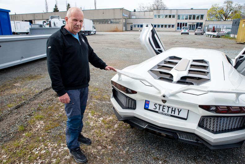 Steinar THyholdt bak bilen, viser frem vingene.