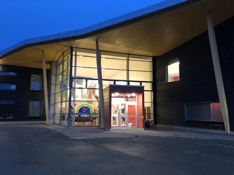 Skolen sett utenfra i vintermørket.