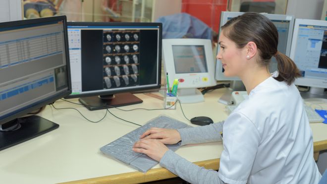 Kvinne bruker datamaskiner på et sykehus.