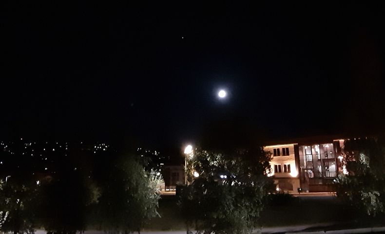 Nattehimmel i Oslo, med månen og Jupiter synlig over hustakene.