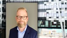 Henrik Larsen er juridisk direktør i Telia Norge og har stevnet Telenor for 500 millioner kroner. Her montert inn i et bilde av Telia-bygget på Økern.