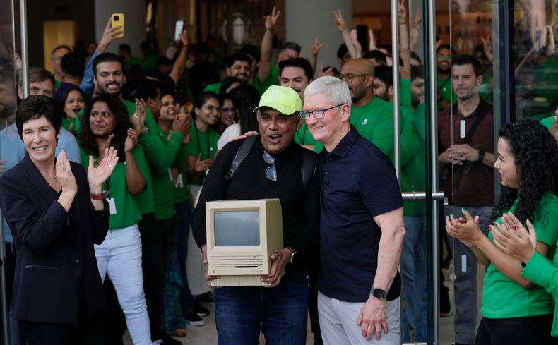 Apple-sjef Tim Cook (t.h.) sammen med en person som holder en gammel Macintosh-maskin.