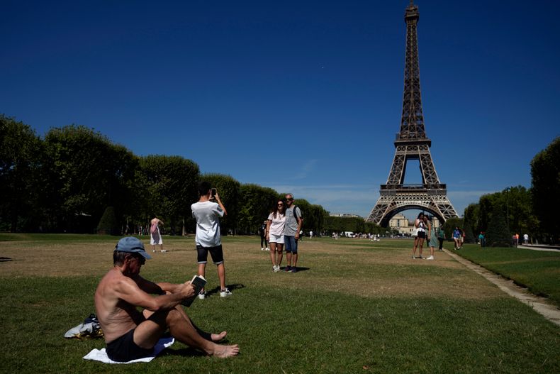 Eiffeltårnet med folk foran i solen.