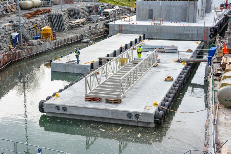 Two docks and a feeder fleet on their way out of Hadal Wharf.  When the installations are completed, seawater is released into the dock so that it floats and can be pulled out.  There are rooms here below sea level. 