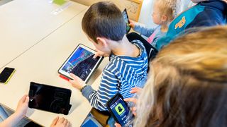 Elever som holder på med mobil og ipader i klassesituasjon på barneskole